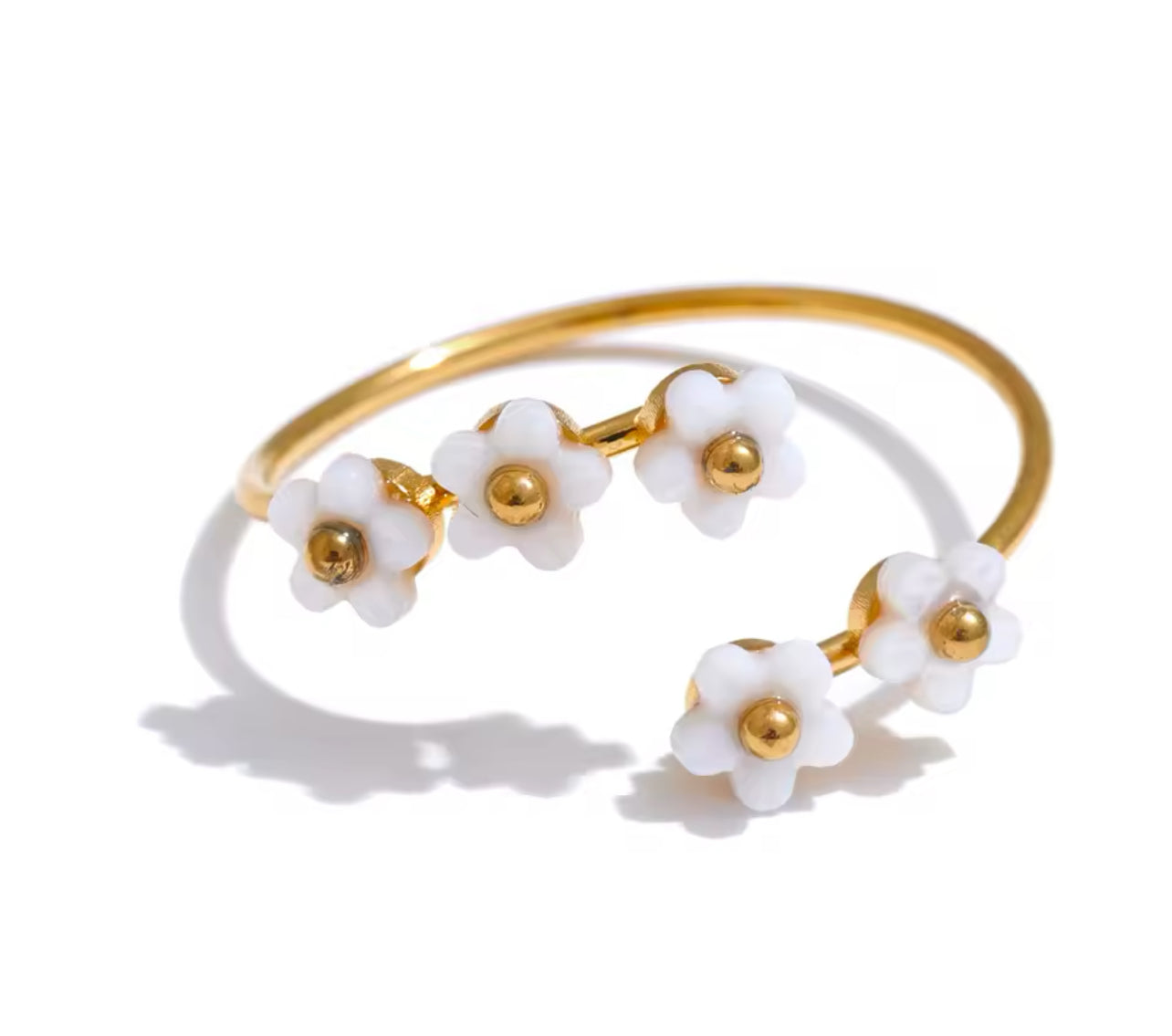 A gold-colored adjustable ring with white shell flower accents.
