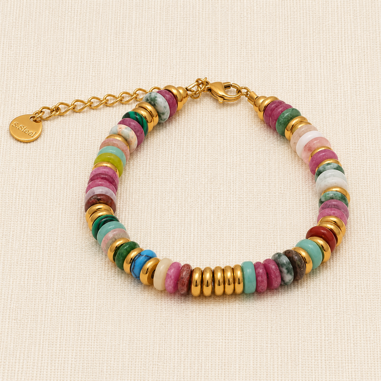 A multi-colored beaded bracelet with gold-plated spacer beads, a gold clasp, and an adjustable gold chain extender. The beads are made of various polished stone discs in pink, green, blue, white, and yellow.