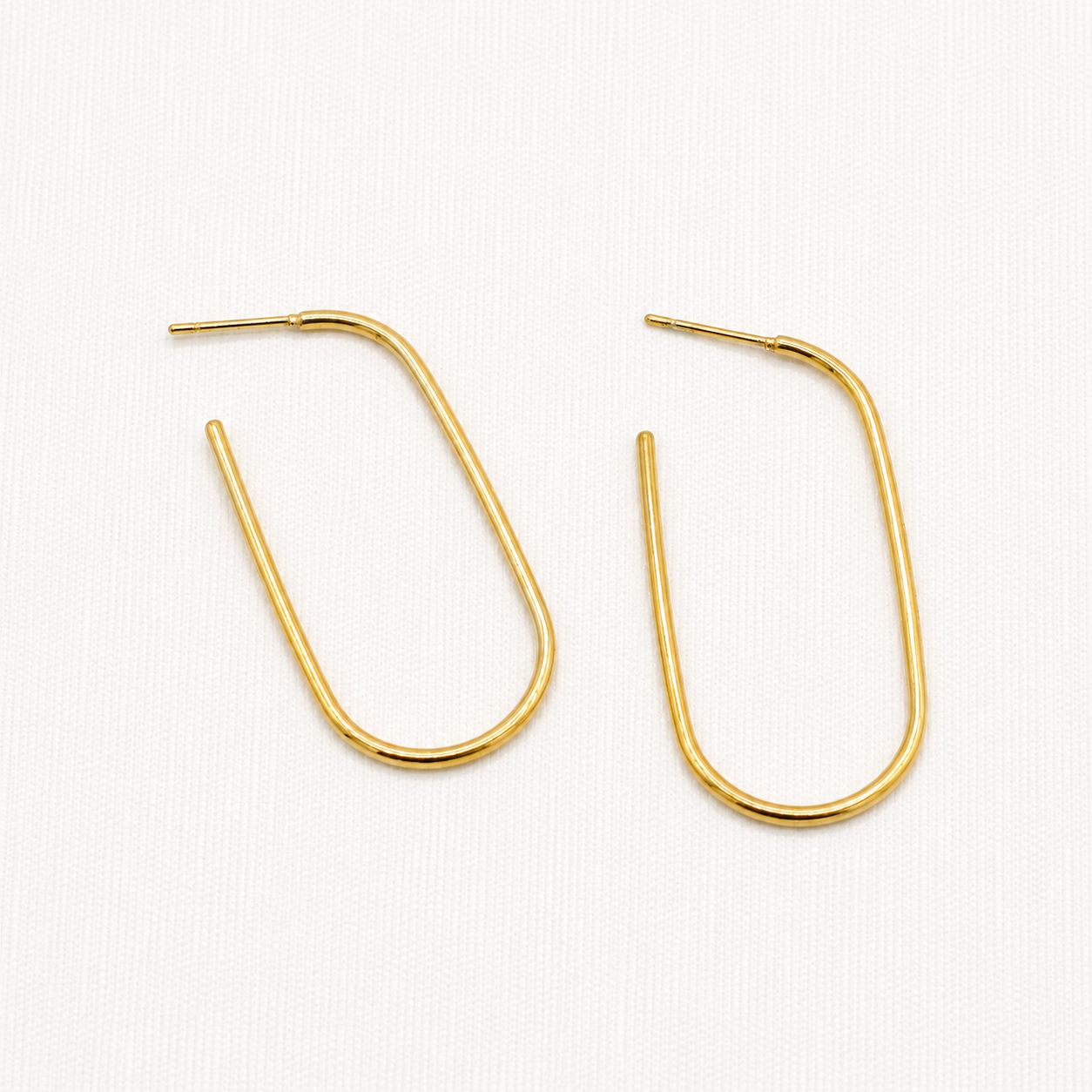 A pair of gold-toned, open hoop earrings with a minimalist U-shape design