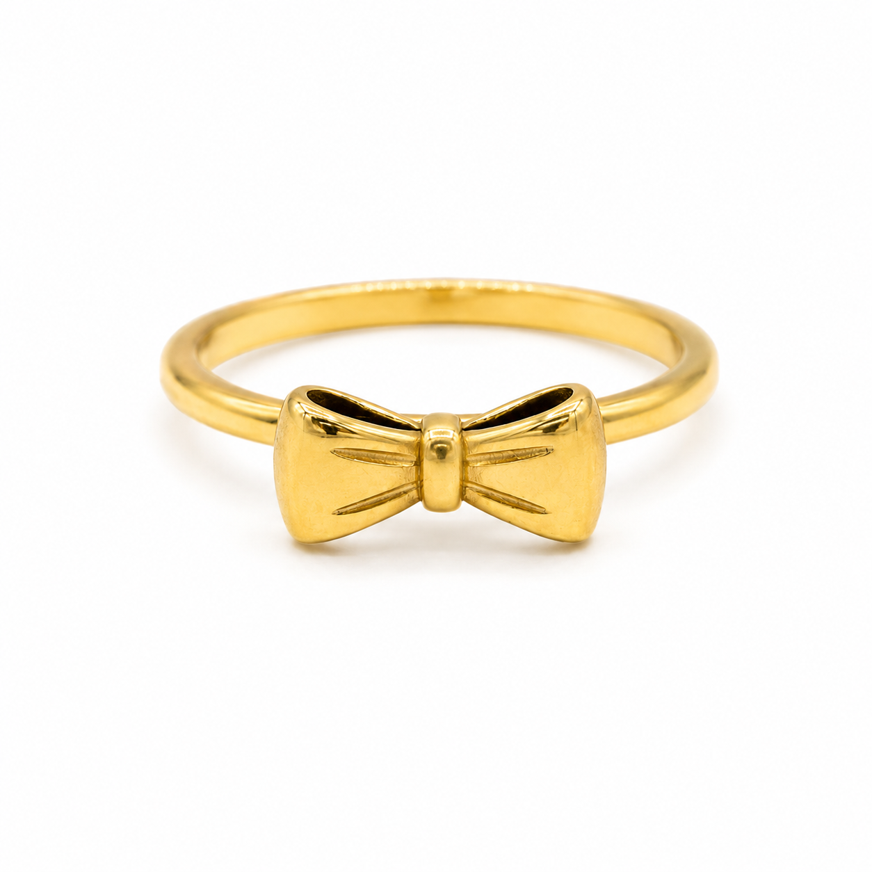 A polished yellow gold ring featuring a small bow-shaped centerpiece