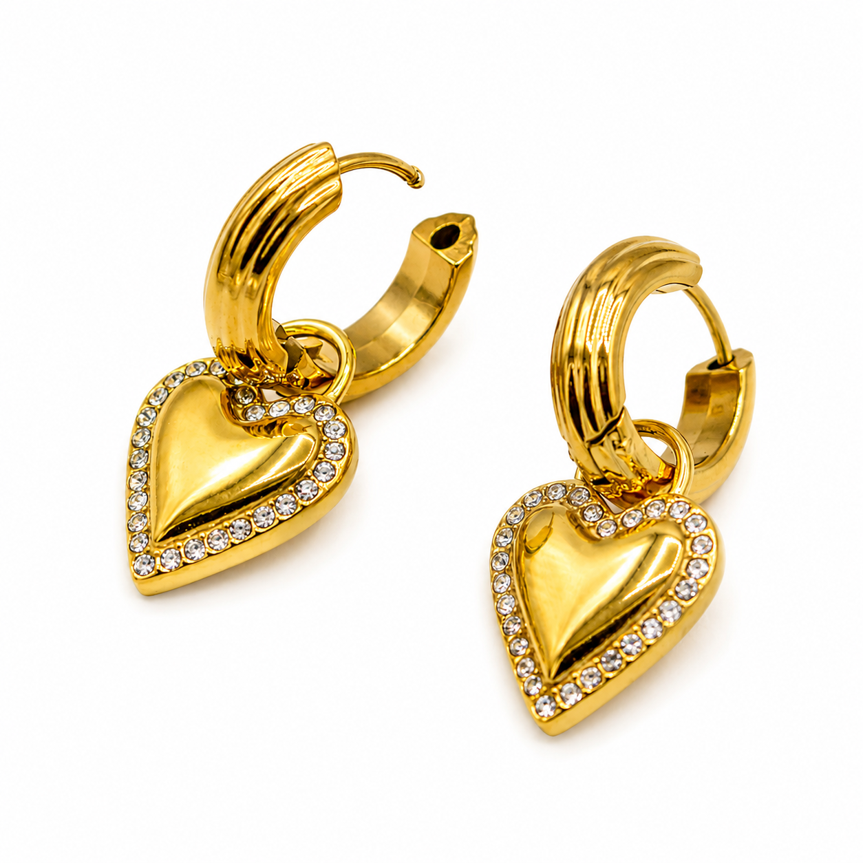A pair of gold hoop earrings with dangling heart charms, accented with small clear stones along the heart borders
