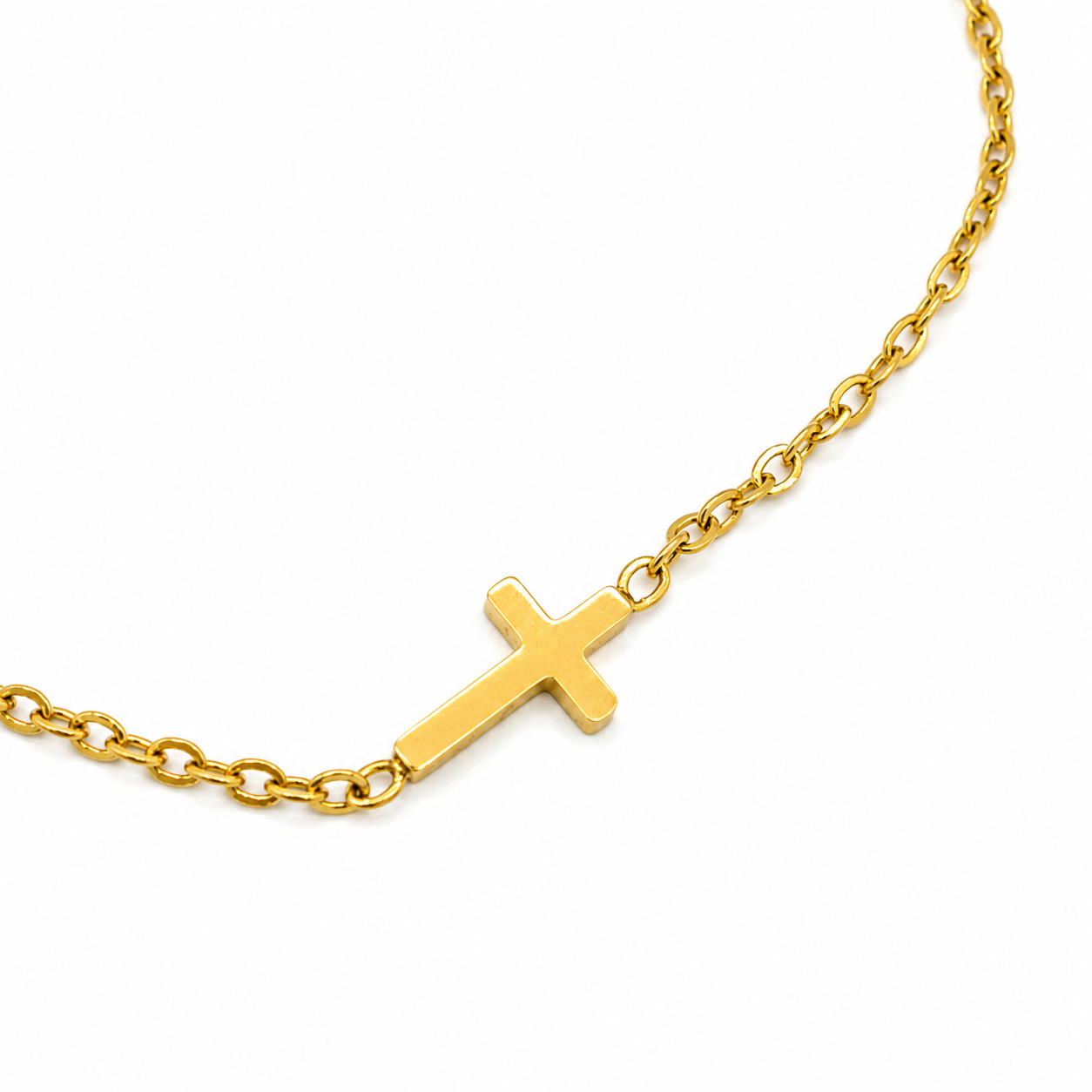 A gold cross pendant necklace on a matching gold chain