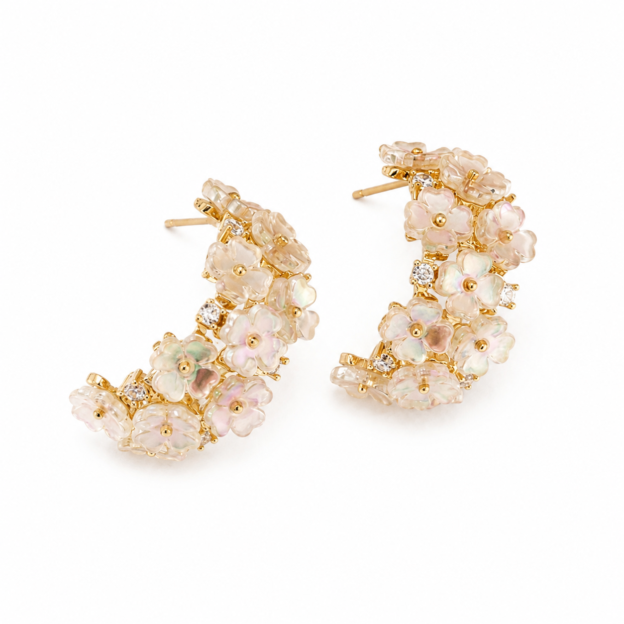 A pair of gold crescent-shaped hoop earrings adorned with clustered pale pink and iridescent flower-like stones