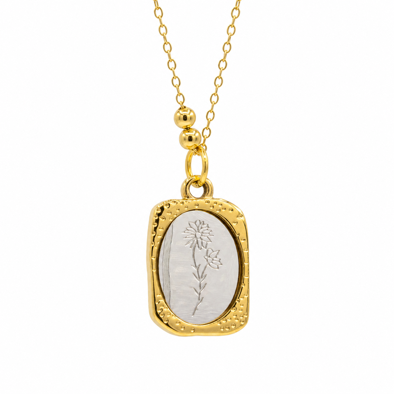 A gold pendant necklace featuring a textured gold border and a central oval inlay with an engraved floral design, suspended from a delicate gold chain