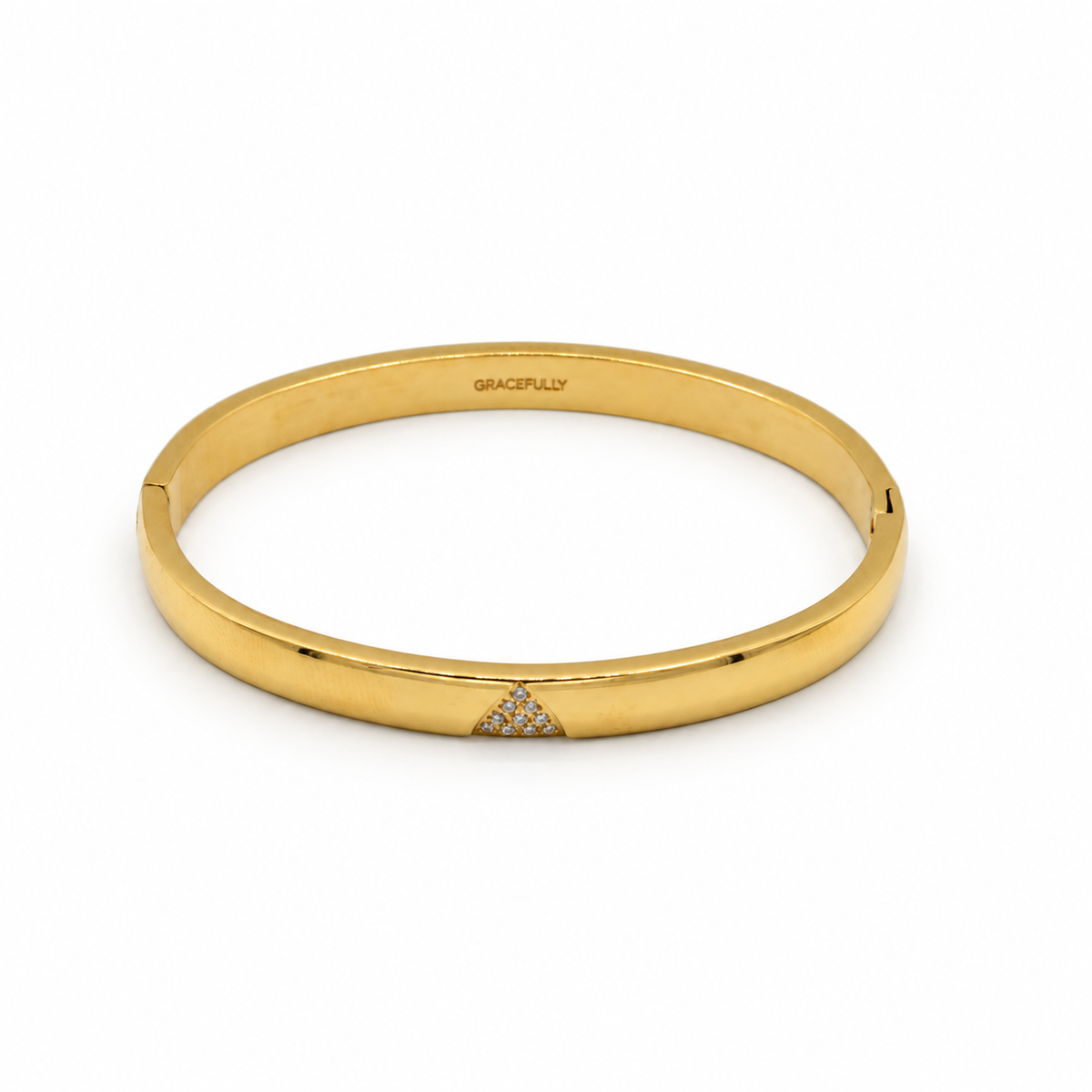 A polished yellow gold hinged bangle bracelet with a small triangular pavé diamond accent on the front