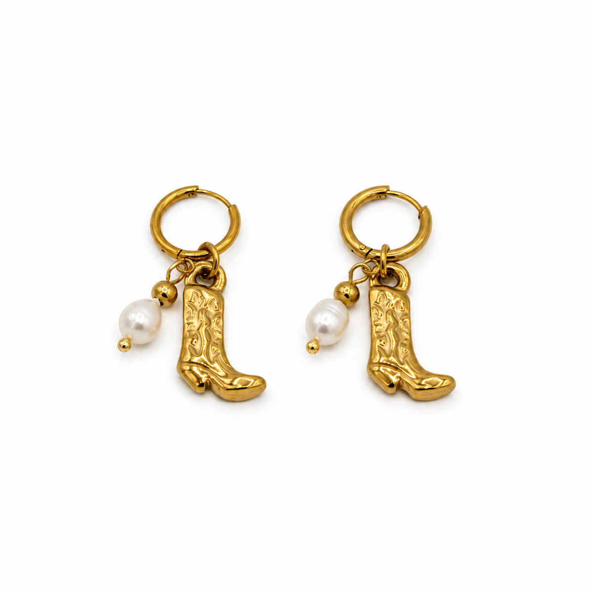 A pair of gold hoop earrings featuring dangling cowboy boot charms and a small white pearl bead