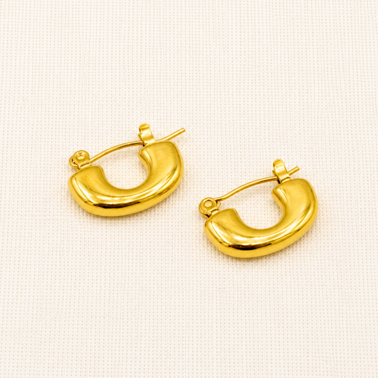 A pair of polished yellow gold crescent-shaped hoop earrings with post-back closures
