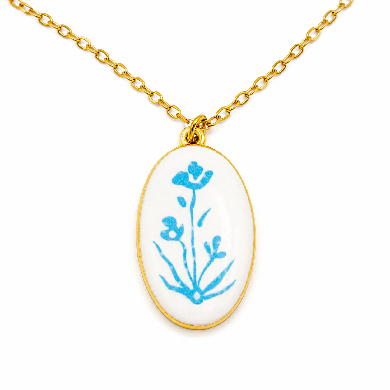 Gold chain necklace with an oval pendant featuring a blue floral design, set in a gold bezel.