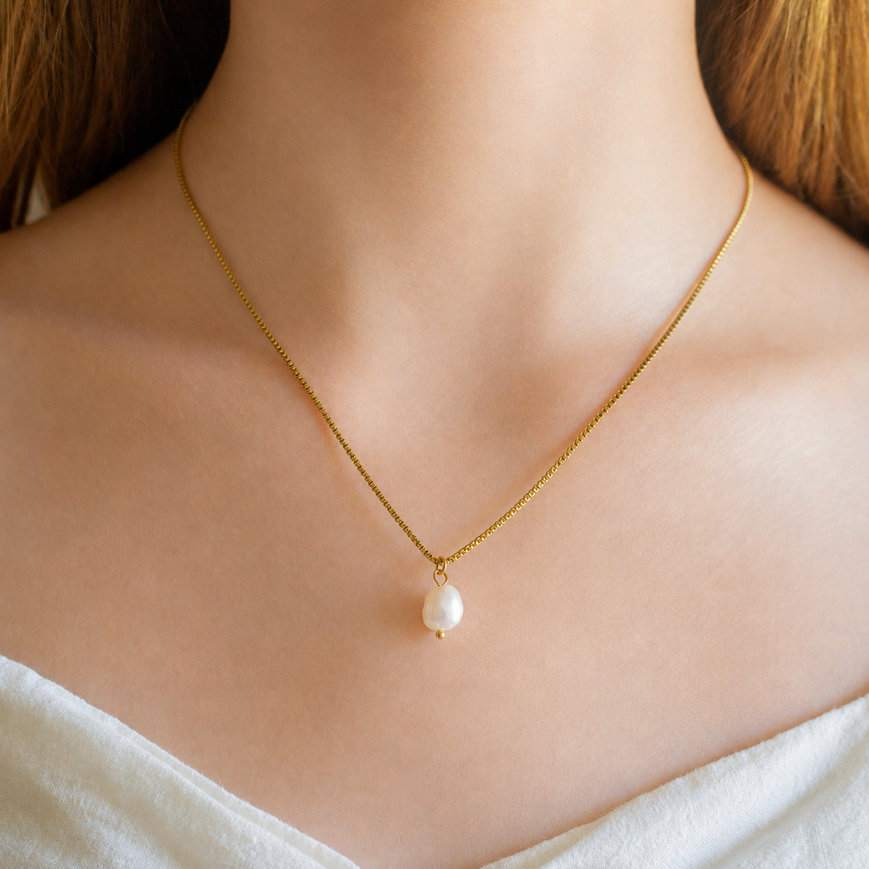 A delicate, shown worn on a model's neck.