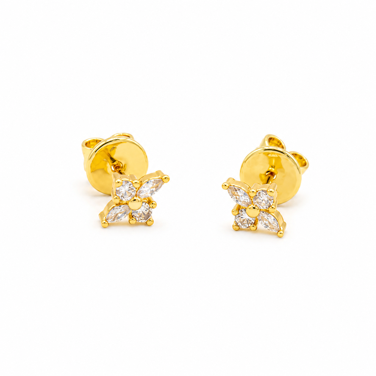 A pair of yellow gold stud earrings featuring a small flower design set with clear baguette and round-cut stones
