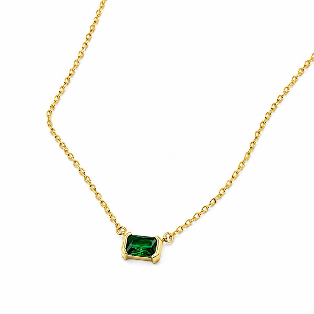 A delicate gold chain necklace featuring a small rectangular emerald-cut green gemstone pendant in a gold bezel setting