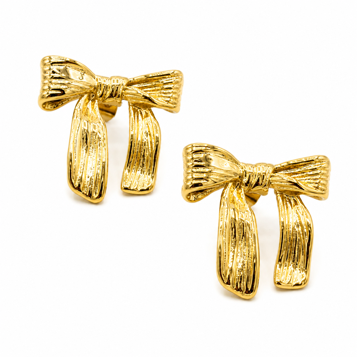 A pair of gold bow-shaped stud earrings with a textured, ribbed finish