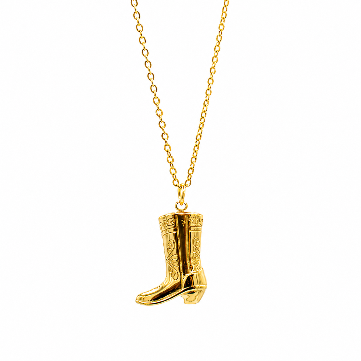 A gold necklace featuring a detailed cowboy boot pendant with engraved western-style patterns, suspended from a delicate gold chain 