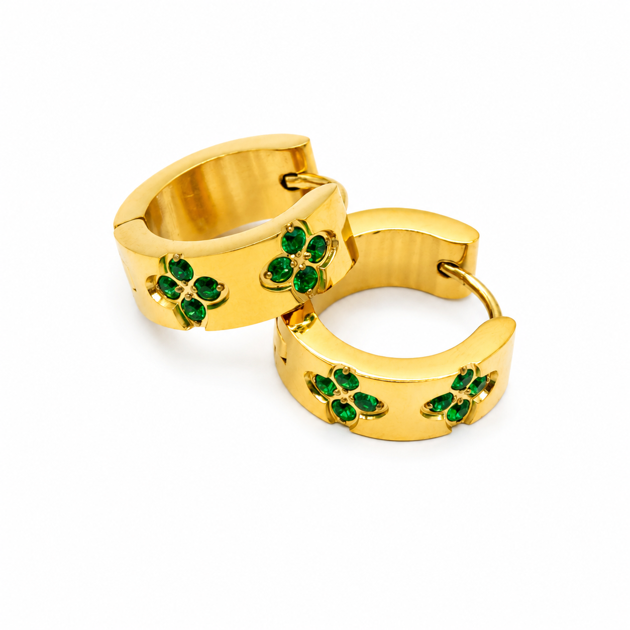 A pair of gold huggie hoop earrings decorated with green four-leaf clover motifs