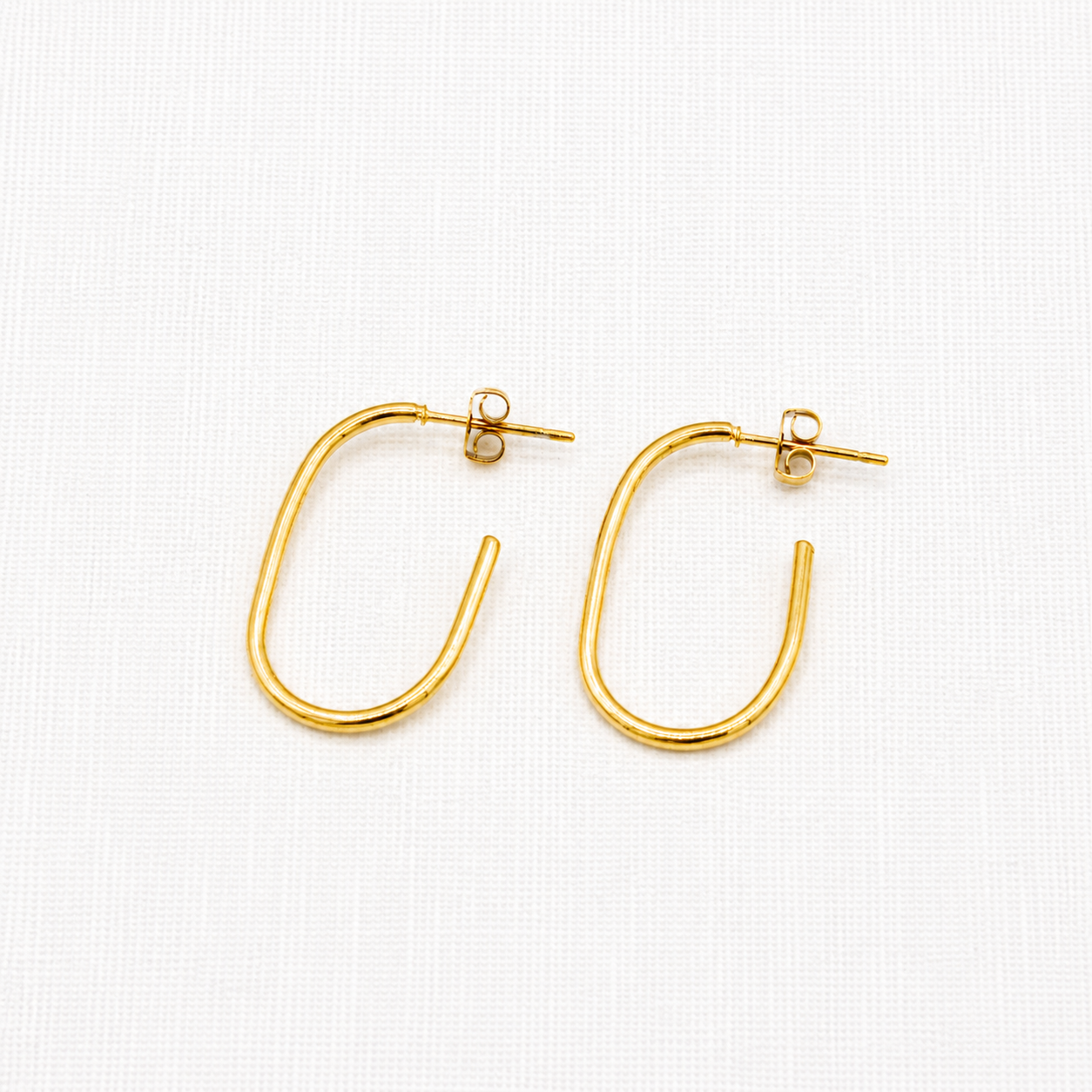 A pair of gold-colored open hoop earrings with post-back closures