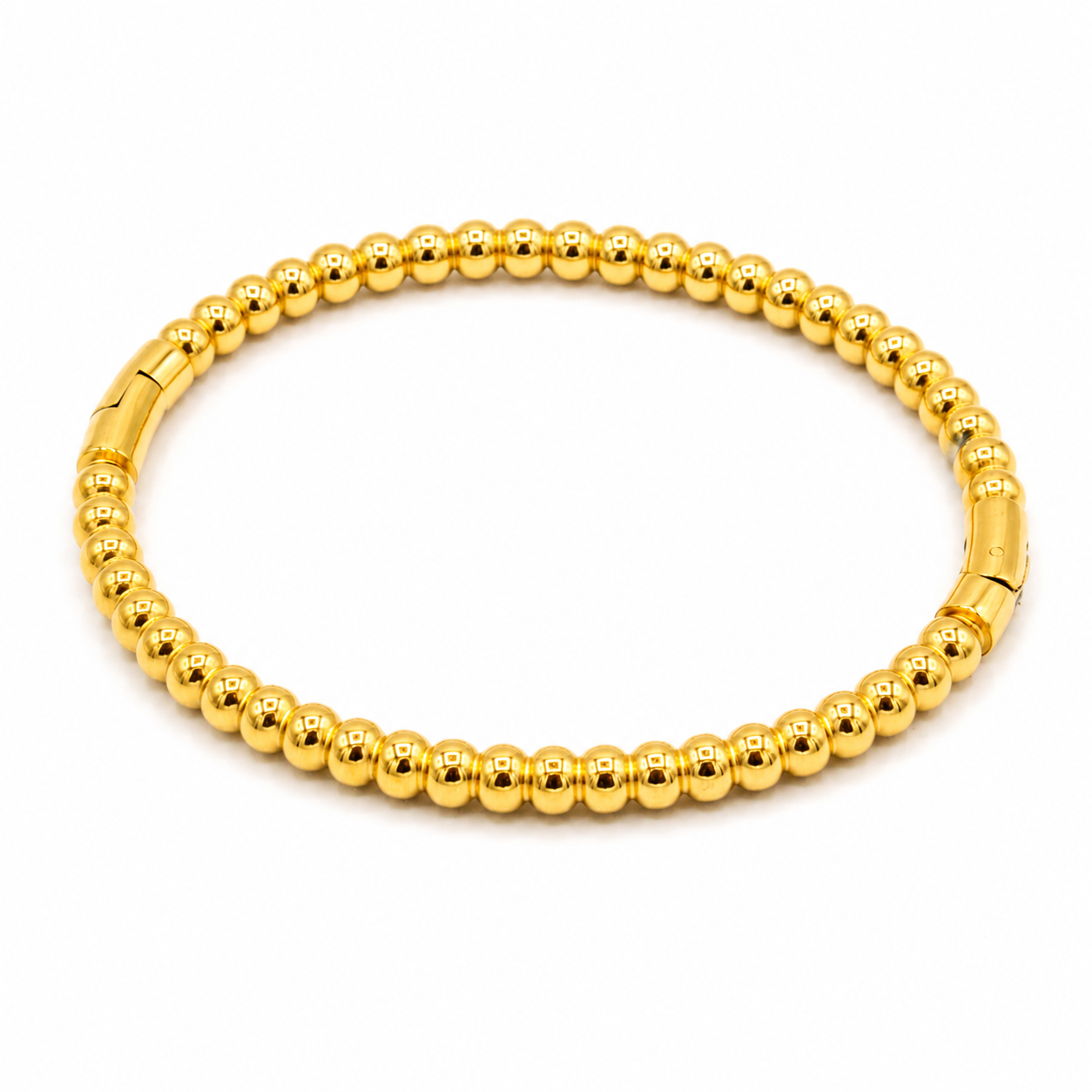 A gold beaded bracelet with a polished finish and a clasp closure