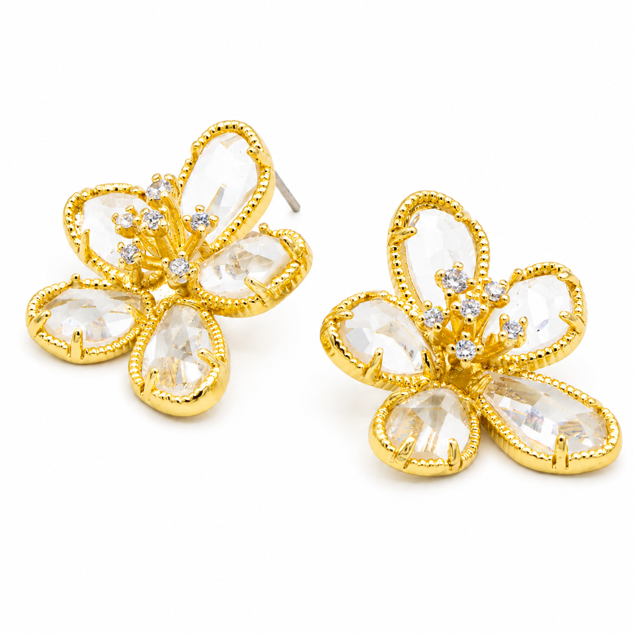 A pair of gold flower-shaped stud earrings with clear teardrop-cut rhinestones and small clear accent stones in the center