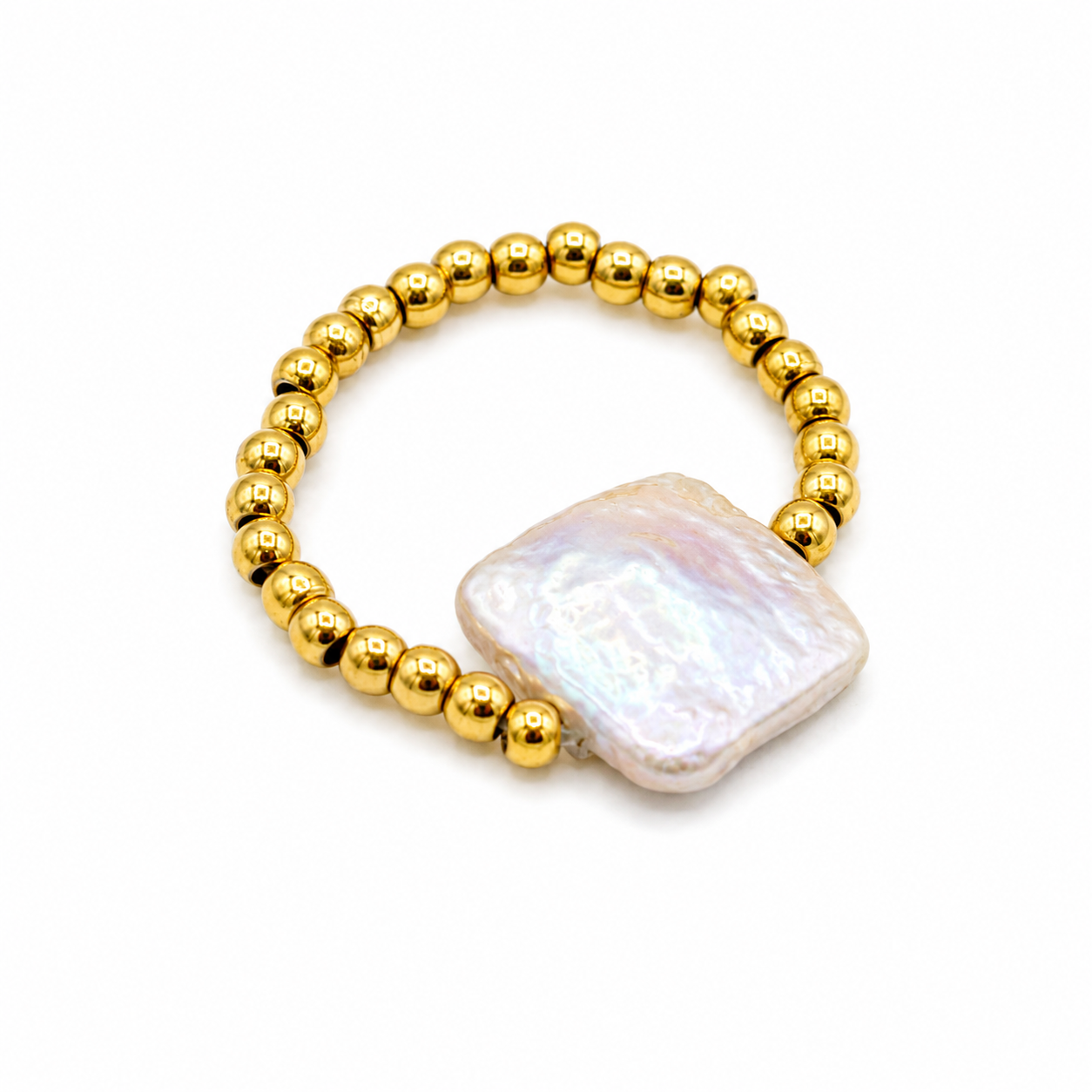 A gold beaded ring featuring a large, irregular-shaped white iridescent shell charm