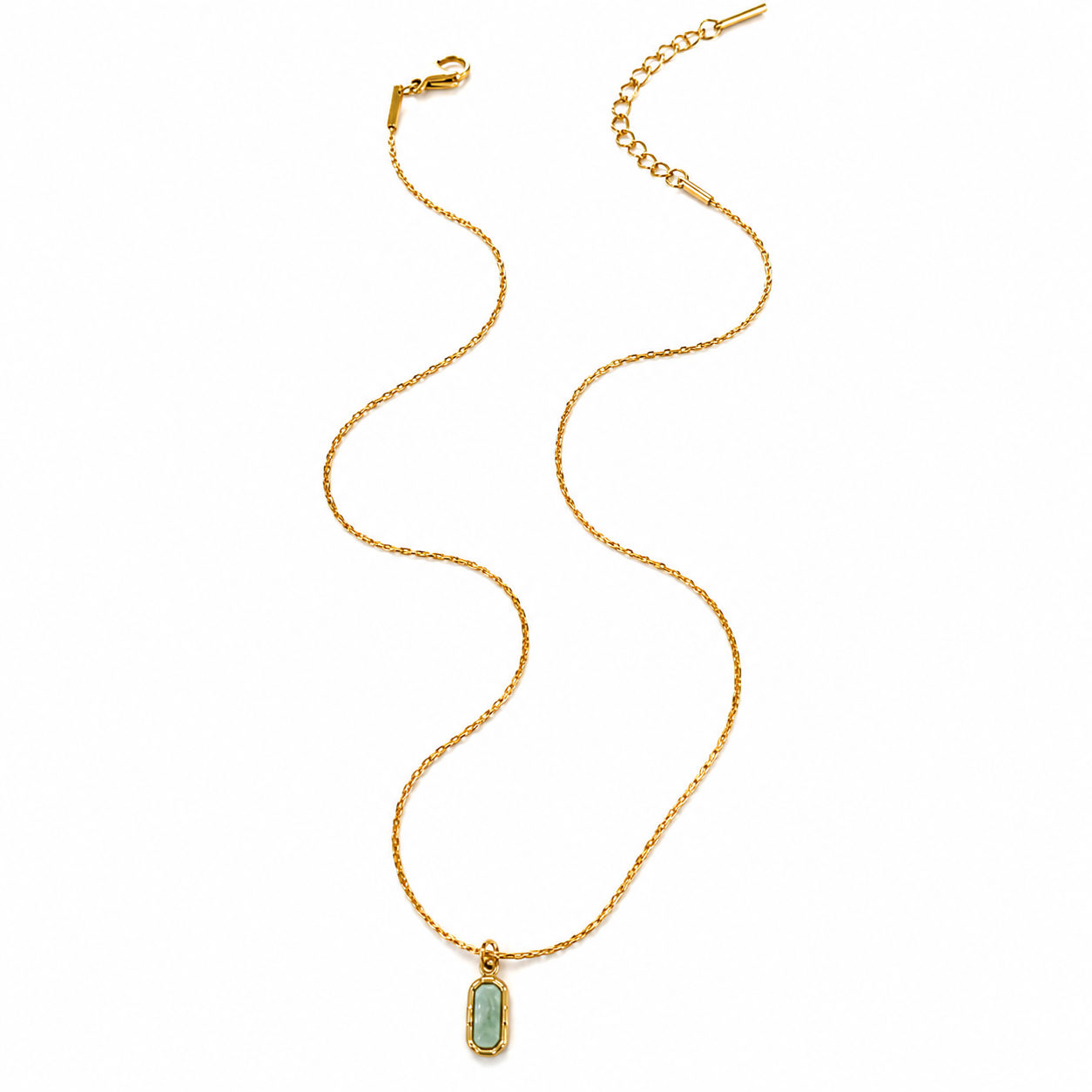 A gold chain necklace with a small rectangular pendant featuring a light green stone