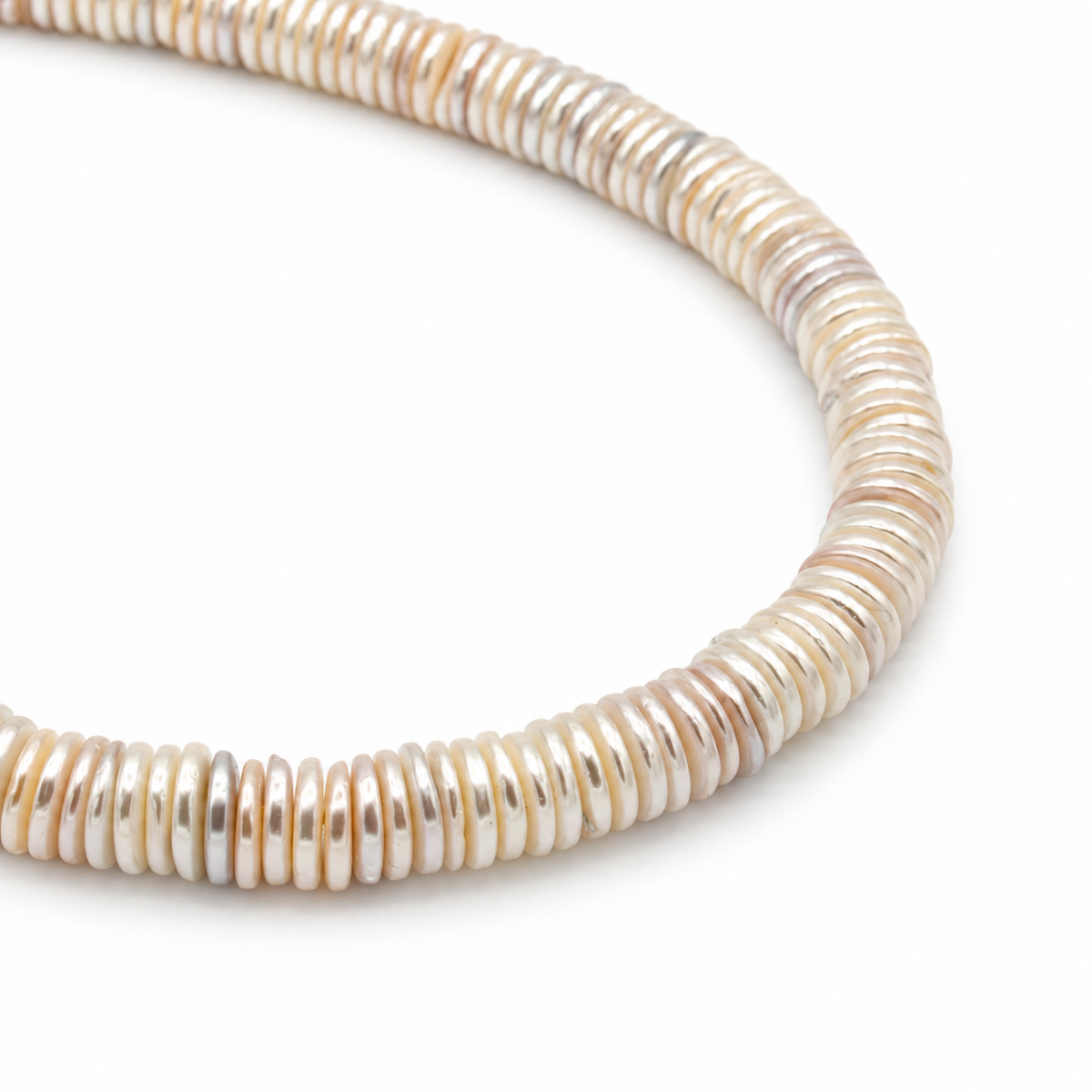 A close-up of a coiled necklace made of small, horizontally stacked disc-like beads in iridescent cream, beige, and soft pink tones
