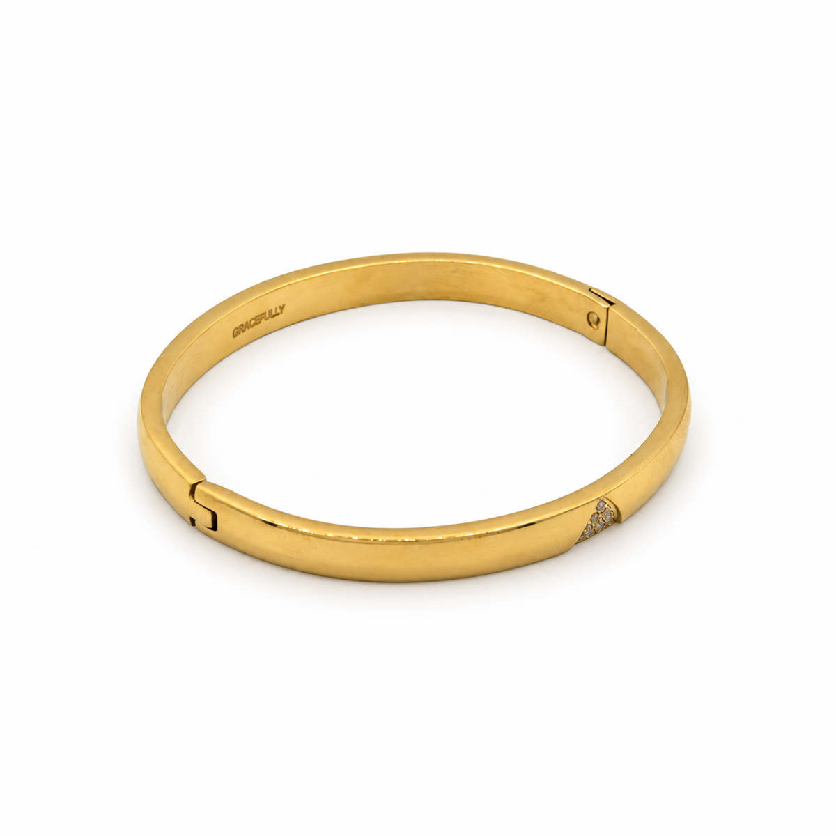 A polished yellow gold hinged bangle bracelet with a small pavé diamond accent on one of the hinge ends