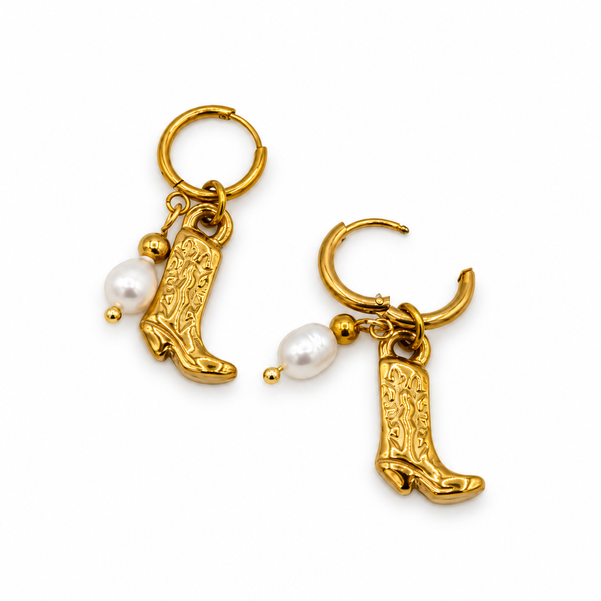 A pair of gold hoop earrings featuring dangling cowboy boot charms and small white pearl beads