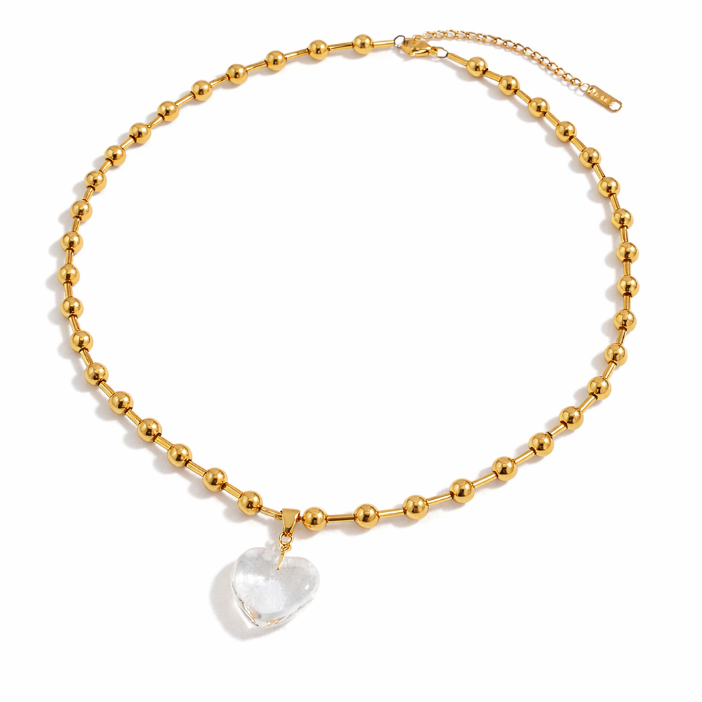 Gold beaded necklace with a clear heart-shaped pendant
