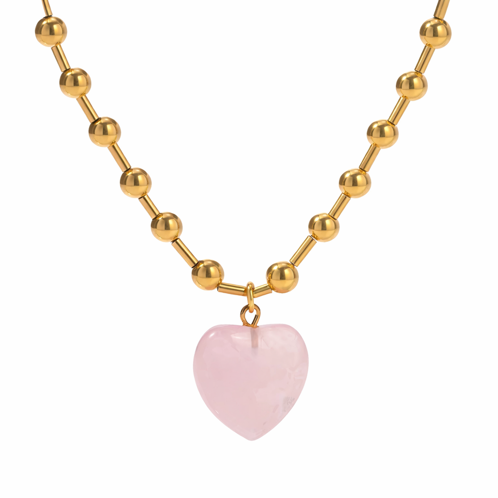 Gold beaded necklace with a pink heart pendant