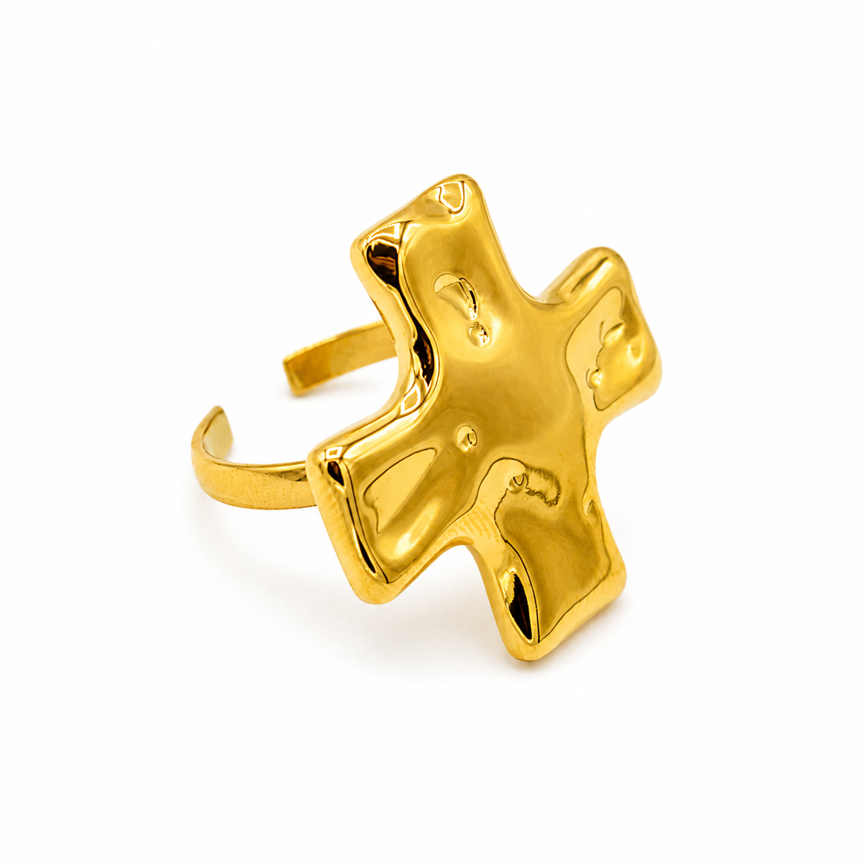 A gold-toned open ring with a large, abstract, glossy cross-shaped face